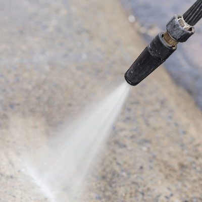 Pressure washer cleaning surface, preparing for what is resurfacing concrete to restore appearance