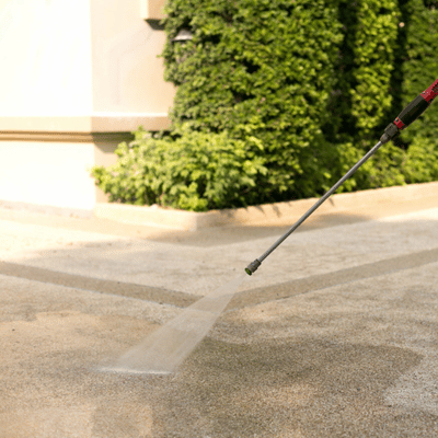 A power washer cleans outdoor concrete to show how long does concrete stain last