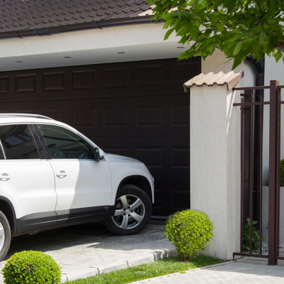 White SUV parked in driveway with garage polished concrete floor visible inside partially open garage