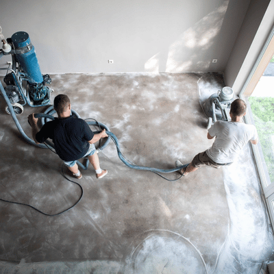 Overhead view shows contractors grinding interior slab; explaining what is concrete resurfacing through practical preparation