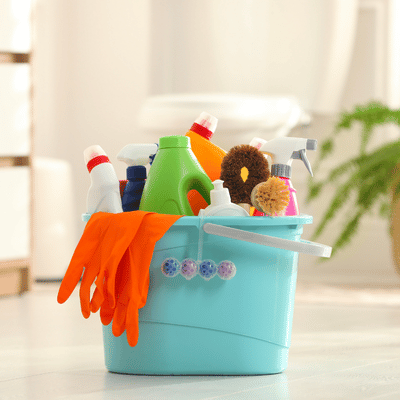 Photo shows cleaning caddy with gloves, sprays, brushes, and bottles for professional concrete staining