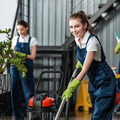 Cleaning crew vacuums floor area after concrete strippers work, removing residue and dust safely